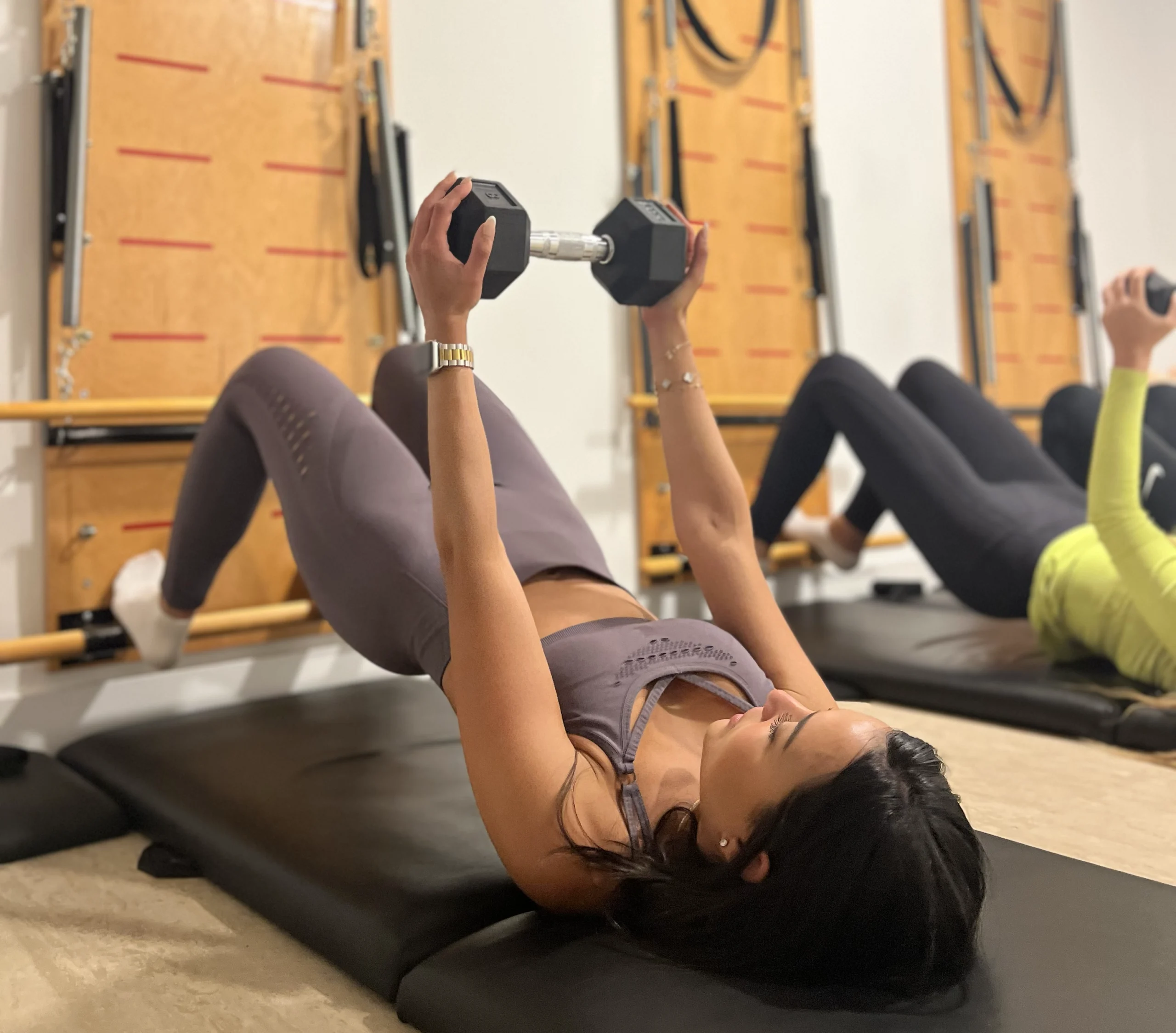 Chica joven y fit haciendo pilates en máquina