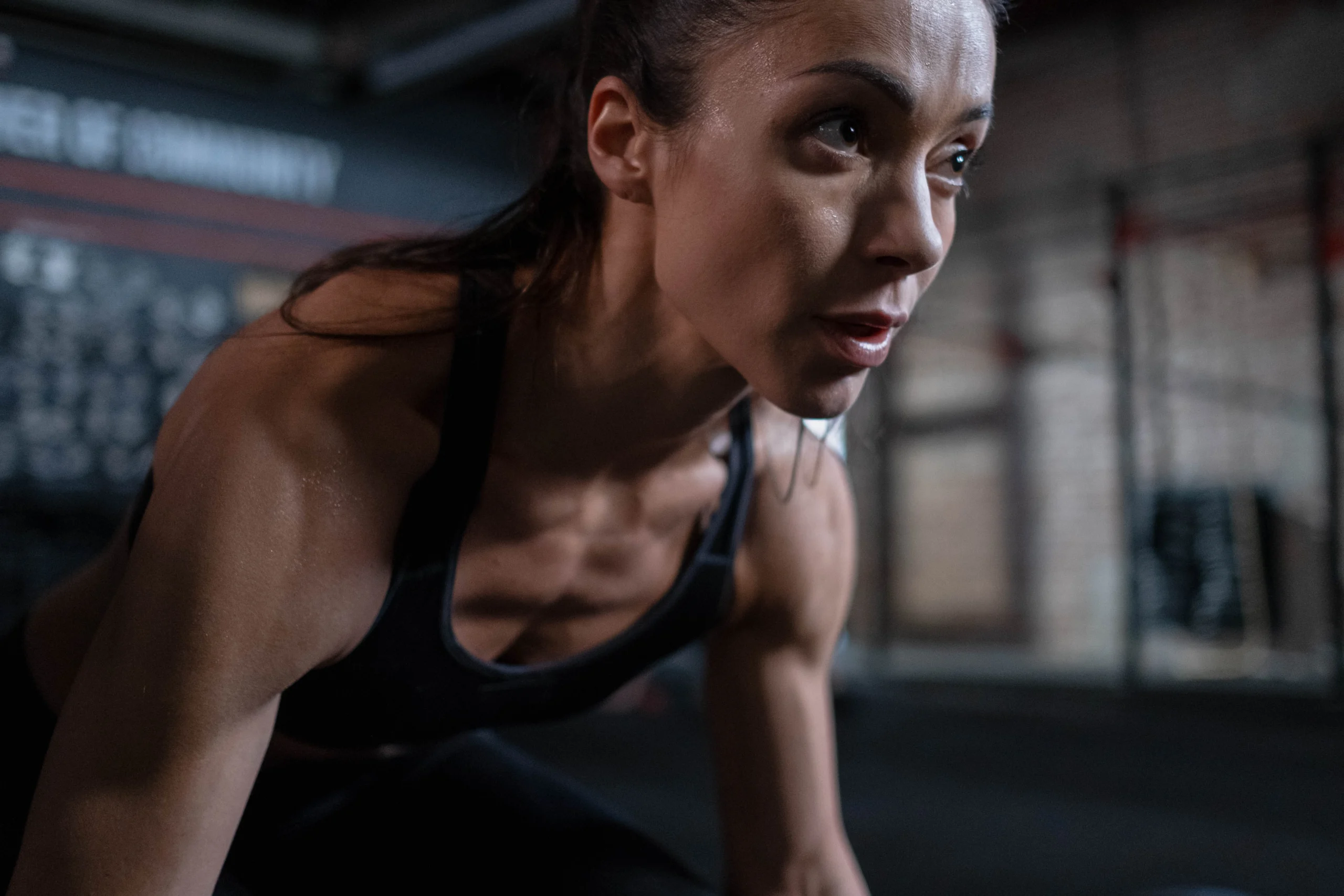 mujer fit mirando hacia la derecha y en posición de comenzar a correr